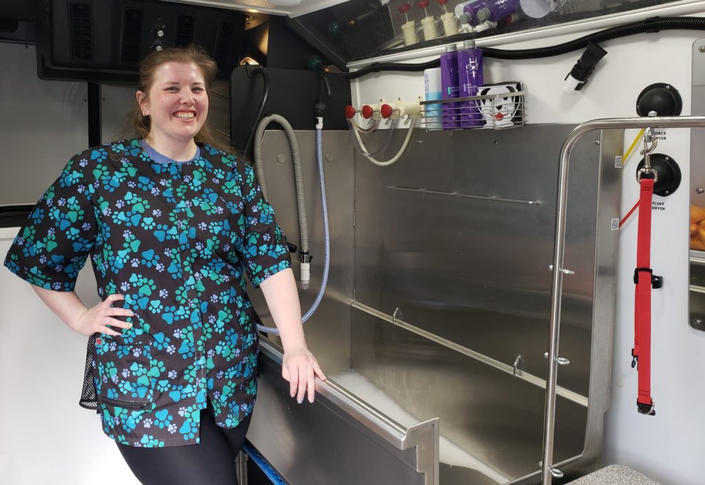 Groomer and business owner Amber Stoehr in the interior of The Secret Groomer mobile grooming vehicle.